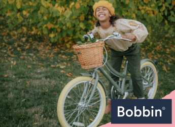 girl happy on pink bike with basket